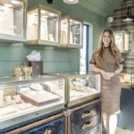 Photo of young woman, Karina Brez, standing inside a jewelry store housed in a upscale mobile space,